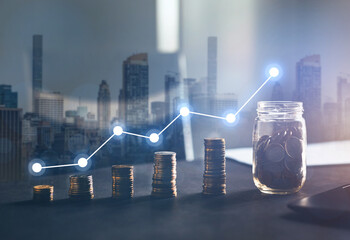 Double exposure of city and stack of coins with digital growth diagram.