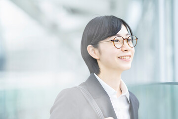 スーツ姿で笑顔を見せる若い女性