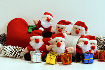 funny santa claus toys with christmas gift boxes on blurred white background