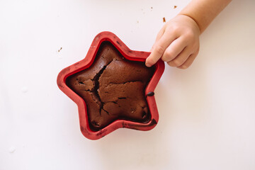 Child Hand is holding Biscuit Hot Homemade Cookies in a red baking dish.