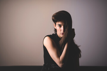 A serious young woman sitting on a sofa