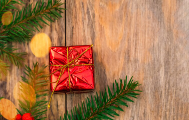 Red gift box with Christmas tree branch on wooden background with copy space,top view.