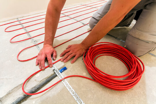 Rothenburg ob der Tauber, Germany - November 12, 2017: Worker installing heating cable for warm floor. Renovation works
