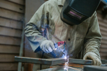 welder is welding metal in workshop