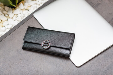 black wallet lies on laptop desks on table