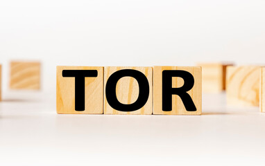 A wooden block with the word TOR The Onion Router written on it on a white background. Business concept © Sviatlana