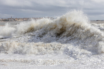 Powerful ocean wave breaking ina windy day