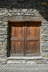 Close-up of the wooden door of an old stone building, typical of the Alpine area, Aosta Valley, Italy