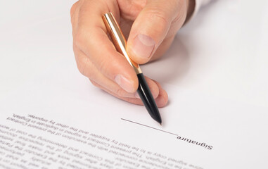 Contract signing concept. Businessman hand with golden pen over document closeup