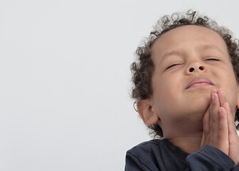 little boy praying to God with hands together with  head held high stock photo 