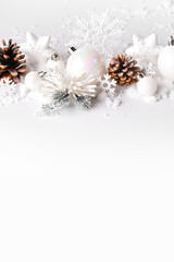 Silver and white Christmas balls and ornaments on white snow background