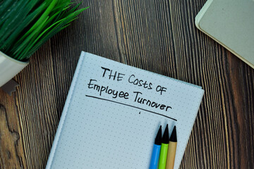 The Costs of Employee Turnover write on a book isolated on Wooden Table.