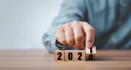 male hand hand putting wood cube for 2021 years. creative background for the new year. happy new years 2021 concept