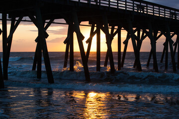 Fototapeta na wymiar Morning waves under the fishing pier