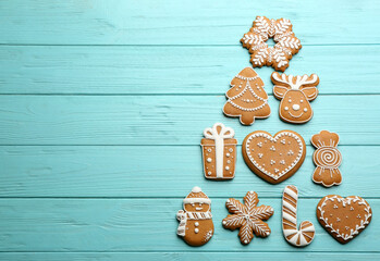 Christmas tree shape made of delicious gingerbread cookies on light blue wooden table, flat lay. Space for text