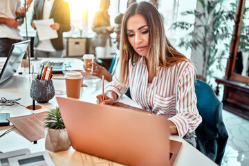 Attractive woman working in office on laptop