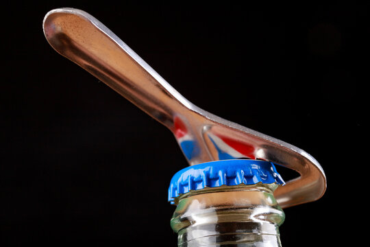 Metal Cap And Opener On The Glass Bottle. An Open Bottle With A Cold Drink.