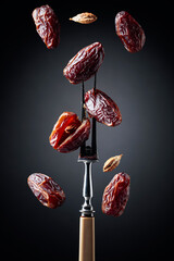 Dried sweet dates on a fork.