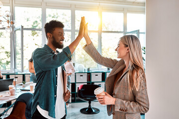 Picture of happy colleagues business team standing in office. Looking aside gives a high-five to...