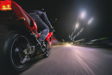 Motorbiker is driving a bike on a night road concept.