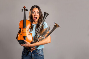 surprised woman holding musical instruments on a gray background