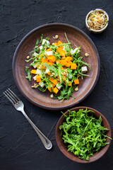 Delicious healthy pumpkin salad with arugula and cheese. Creative atmospheric decoration