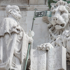 Winged lion with a Bible and a priest at Basilica San Marco in Venice, Italy, summer time, details,...