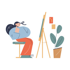 Fototapeta premium Woman sitting opposite easel with artwork and thinking about details in art studio