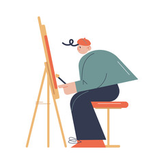 Man artist sitting and drawing on easel with brush in art studio