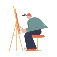 Fototapeta premium Man artist sitting and drawing on easel with brush in art studio