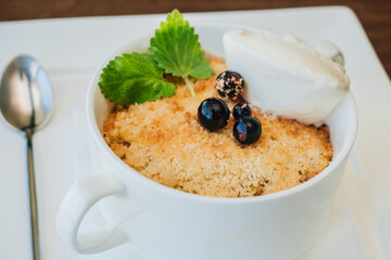 Curd dessert with berries and ice cream with mint leaves. Cottage cheese pie. Cheesecake with berries and sour cream in a white bowl