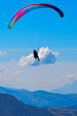 a paraglider, mountains near and far