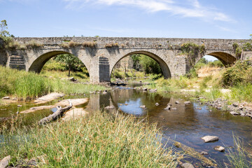 Fototapeta premium antique bridge over Ribeira das Cabras river next to Pinhel, Guarda district, Beira Alta province, Portugal