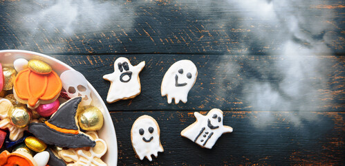 pumpkin in a black witch hat, a bowl of chocolates and sweets, Halloween Jack o Lantern cookies - Trick or Treat Halloween card background