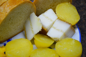 a snack for vodka made from bread, baked potatoes and bacon on a blue saucer