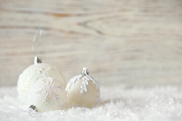 Beautiful Christmas balls on snow against blurred background. Space for text