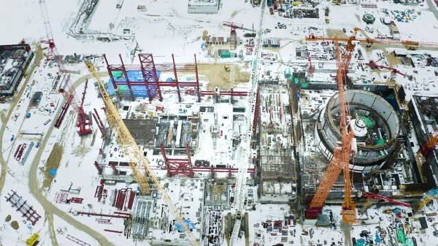 Aerial view of the construction of a nuclear power plant. Creation of nuclear power. Clean, green energy for the future. Winter carbon dioxide emissions. Ecology and pollution of nature.