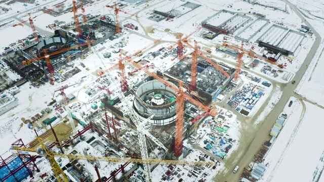 Aerial view of the construction of a nuclear power plant. Creation of nuclear power. Clean, green energy for the future. Winter carbon dioxide emissions. Ecology and pollution of nature.