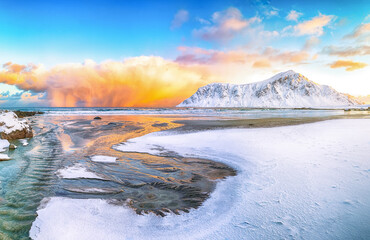 Outstanding  winter scenery on Skagsanden beach with illuminated clouds during sunrise.