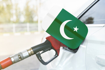 Flag of Pakistan on the car's fuel filler flap with gas pump nozzle in the tank.