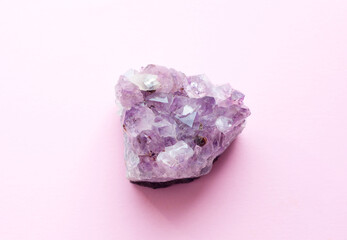 Beautiful druse of natural purple mineral amethyst on a pink background. Large crystals of a gem.