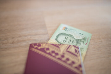 Twenty Thai Baht Bill Partially Inside a Sweden Passport