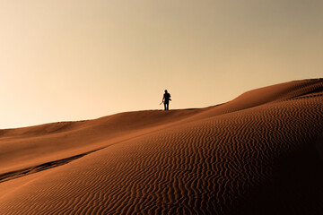 Fototapeta na wymiar A person walking in the desert.