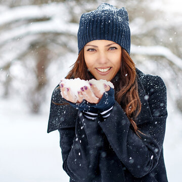 Woman playing with snow in winter park