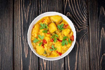 Aloo Gobi side dish. Traditional spicy vegetarian indian curry dish with potatoes, cauliflower, spinach with spices