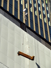 建設中の高層ビルのクレーンで吊り揚げる鉄骨