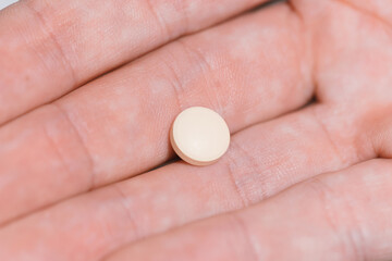 close up. white pill into the palm.