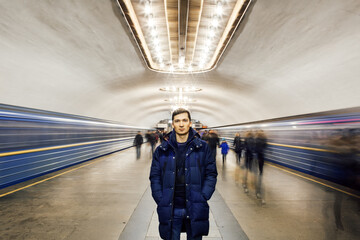 A man stands at the metro station. Motion blur subway and people waiting at subway station.