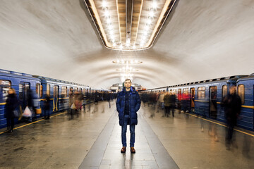 A man stands at the metro station. Motion blur subway and people waiting at subway station.