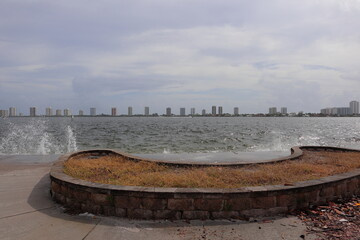 Waves crashing on the seawall looking east towards the singer island skyline. 